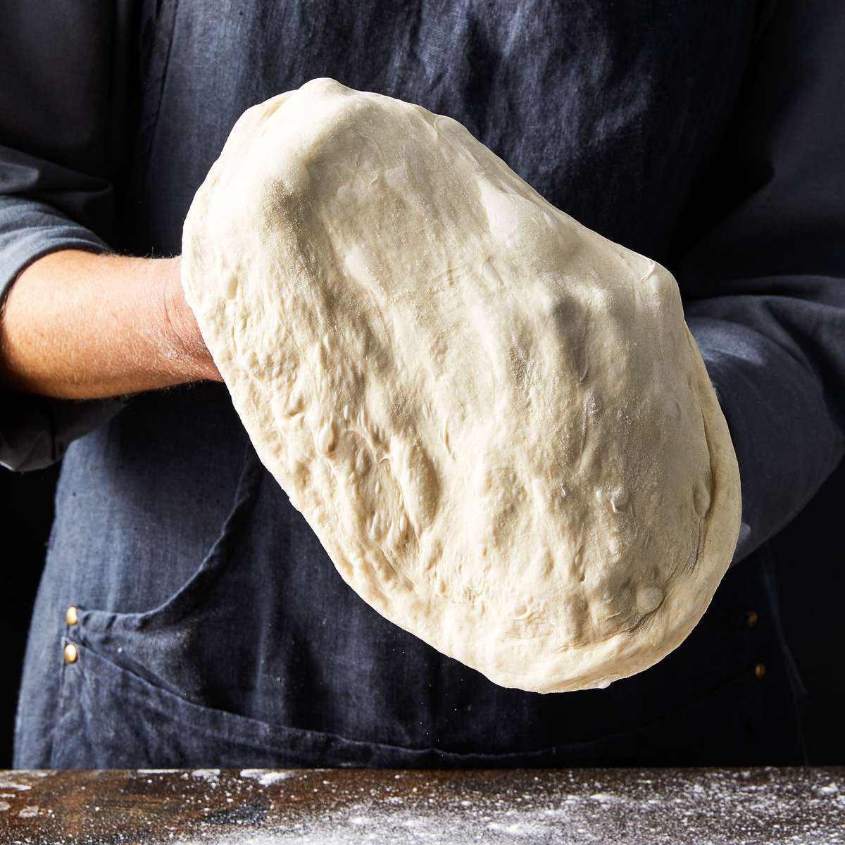 gently stretching pizza dough