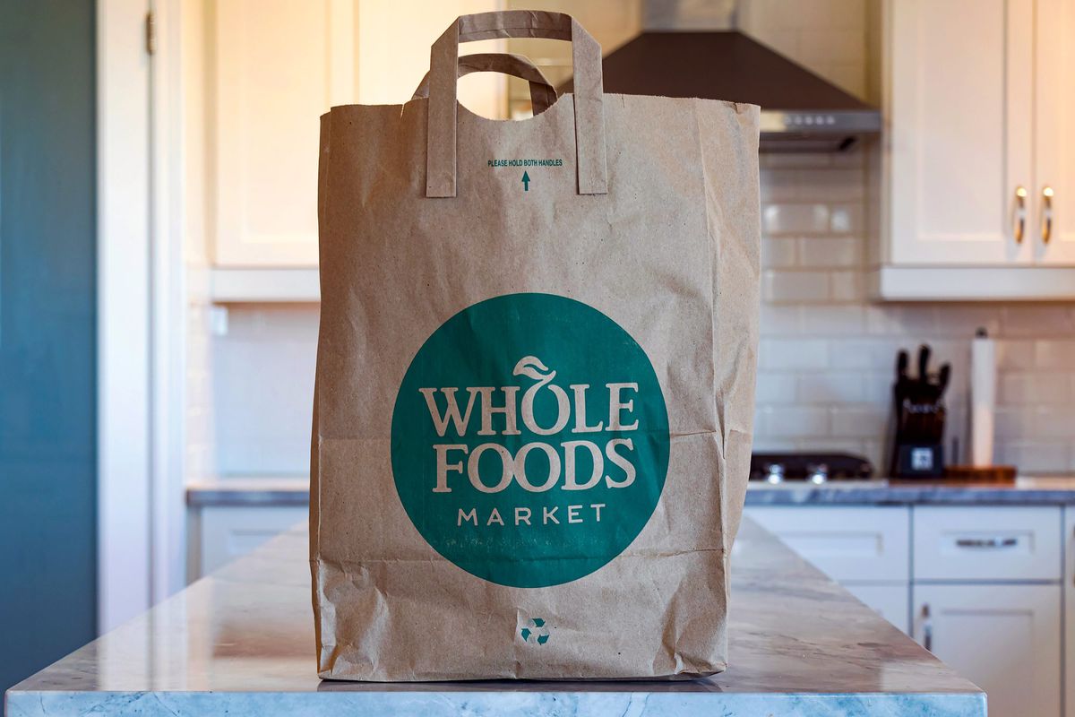 A Whole Foods Market grocery bag on a kitchen counter