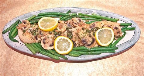 A rectangular white platter holding chicken cutlets with capers and. chicken piccata recipe